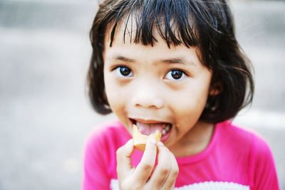 Portrait of cute girl eating food outdoors