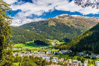 Scenic view of townscape and mountains against sky