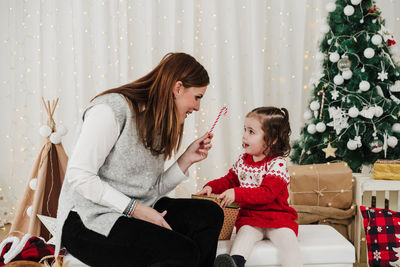 Mother and daughter sitting on sofa at home