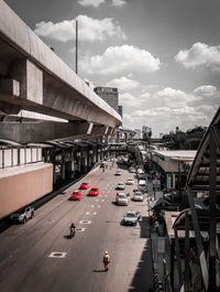 Vehicles on road in city against sky