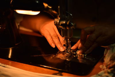 Close-up of person stitching on sewing machine at home