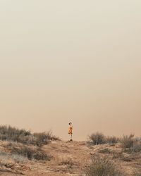 Man standing on field against clear sky