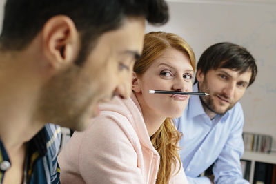 Portrait of playful young woman with colleagues in office