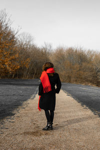 Rear view of woman walking on footpath during winter