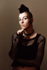 Portrait of beautiful young woman against wall