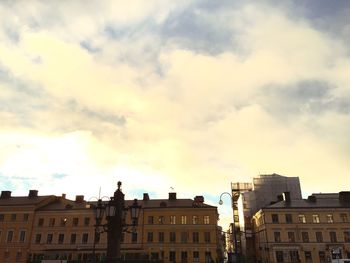 Low angle view of buildings against cloudy sky