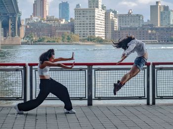 Full length of woman on railing against cityscape in city