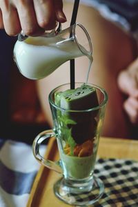 Midsection of person pouring drink in glass