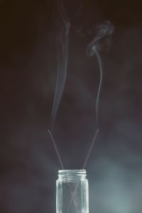 Close-up of glass jar against black background