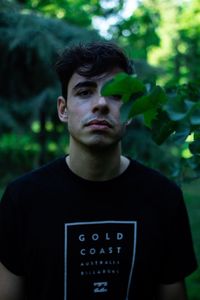 Portrait of young man standing against plants