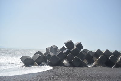 Stack of stones on beach against clear sky