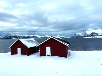 Houses on snow covered landscape against sky