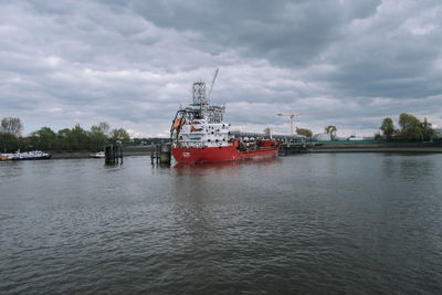 Ship sailing on river against sky