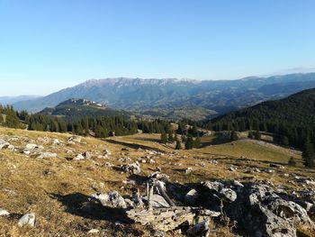 Scenic view of landscape and mountains against clear blue sky