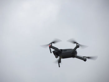 Low angle view of drone flying against sky