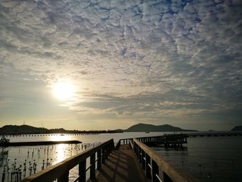 Pier over lake against sky during sunset