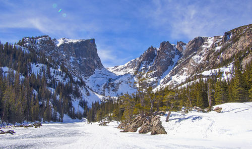 Scenic view of snow covered field by mountains against sky