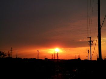 Silhouette of electricity pylon at sunset