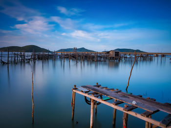 Wooden bridge over river against sky