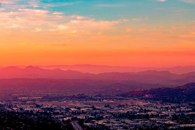 Scenic view of silhouette mountains against dramatic sky during sunset