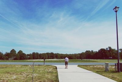 Man standing on grass against sky