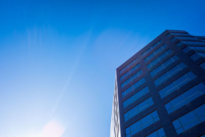 Low angle view of modern building against clear blue sky