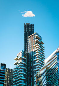 Low angle view of modern buildings against blue sky