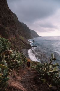 Rear view of woman standing against sea and sky