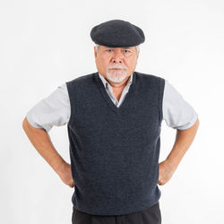 Portrait of man wearing hat standing against white background