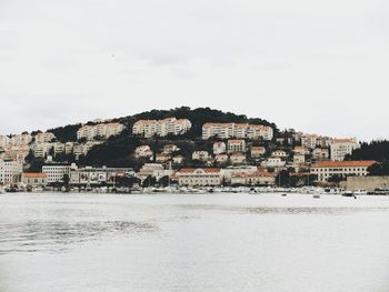 Houses by sea against sky in town