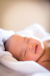 Close-up of newborn baby smiling while sleeping