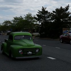 Cars on road against cloudy sky