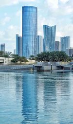 Swimming pool by river against buildings in city