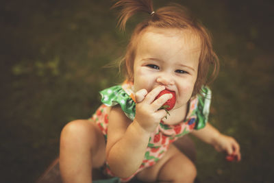 Girl eating strawberries in summer
