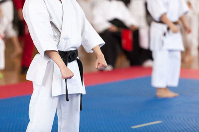 Midsection of man standing on stage during karate competition