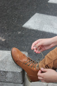 Low section of man tying shoelace on road