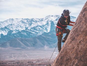 Rear view of man on snowcapped mountain against sky