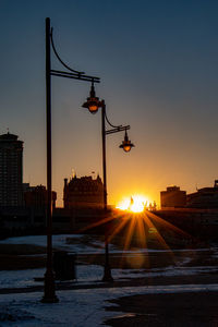 Street amidst buildings in city during sunset