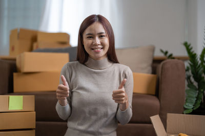 Portrait of young woman sitting on sofa at home