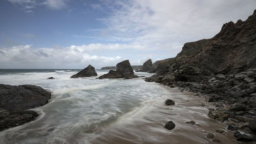 Rocks on sea shore against sky