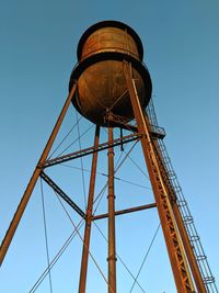 Low angle view of water tower against clear blue sky