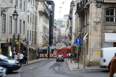 Vehicles on road amidst buildings in city