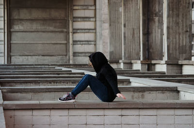 Woman sitting against wall