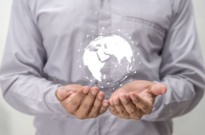 Midsection of man holding illustrative globe