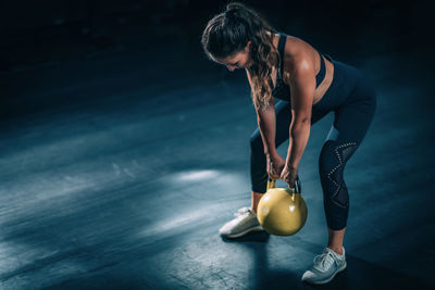 Woman swinging kettlebell in the gym.