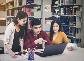 Students discussing over laptop at table