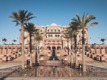 Palm trees in city against clear sky