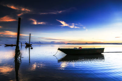 Sailboats in sea against sky during sunset