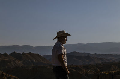 Side view of adult man in cowboy hat in desert. almeria, spain