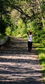 Rear view of woman walking on footpath